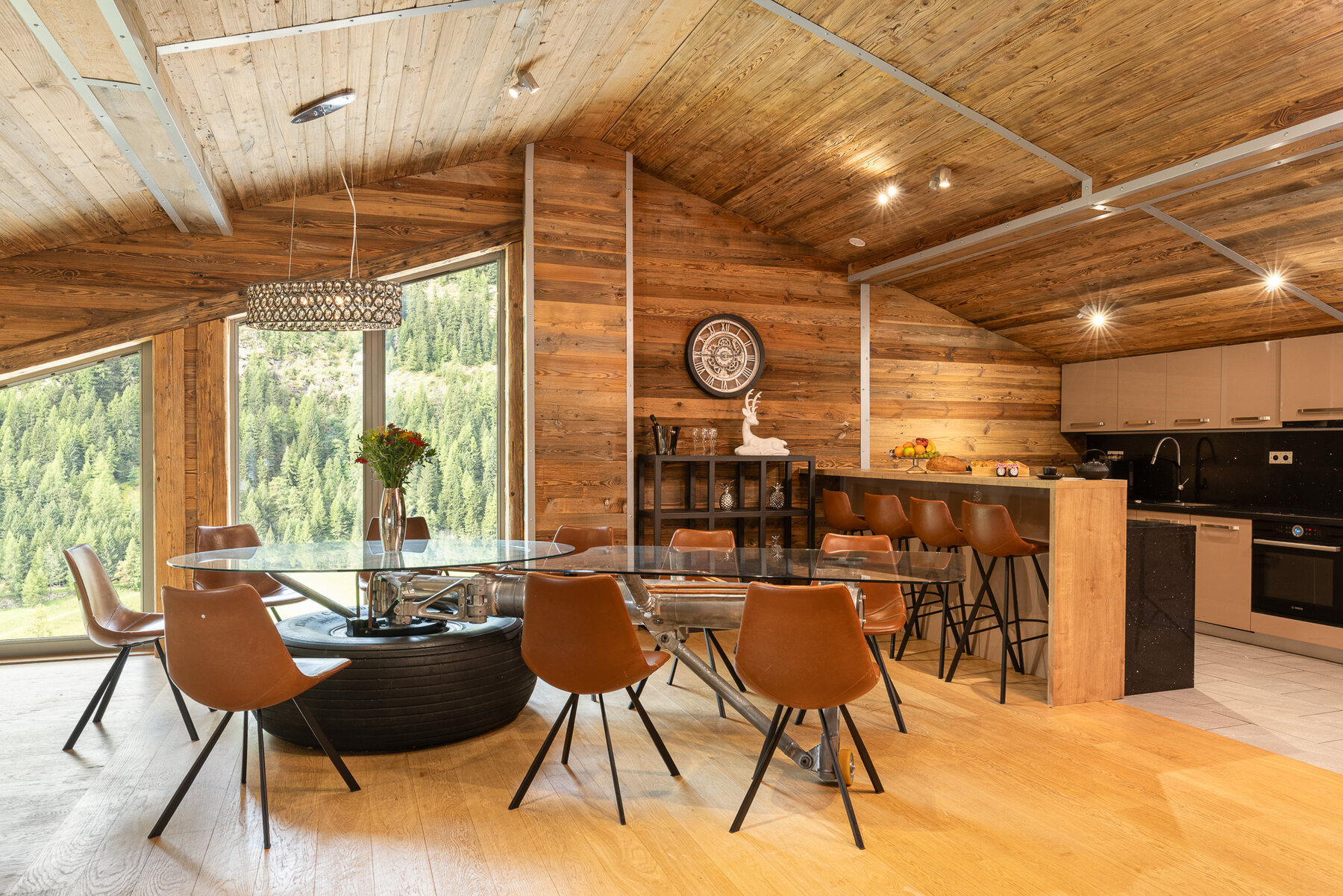 Chalet Aviator's open kitchen and dining area in Tignes, with full-height windows onto the mountains