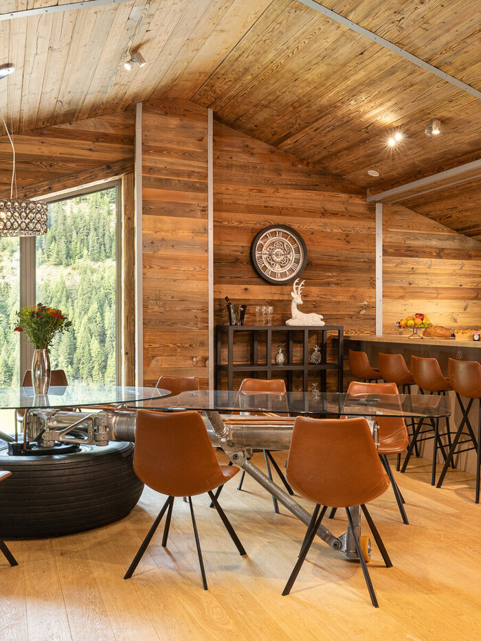 Chalet Aviator's open kitchen and dining area in Tignes, with full-height windows onto the mountains