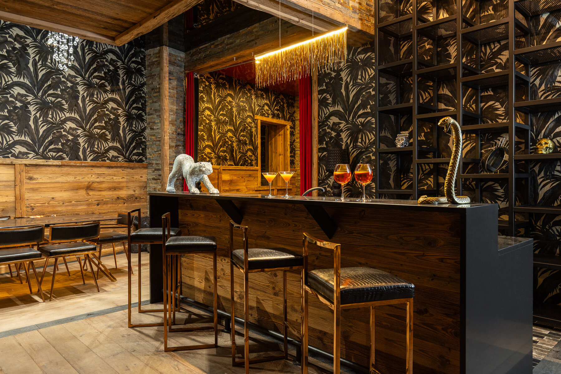 The black-and-gold Gatsby bar at Chalet Gatsby in Tignes, with cocktails and a mosaic cheetah sculpture
