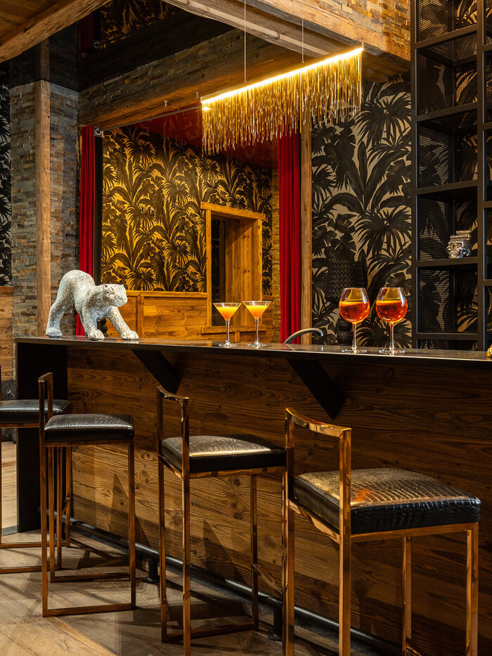 The black-and-gold Gatsby bar at Chalet Gatsby in Tignes, with cocktails and a mosaic cheetah sculpture