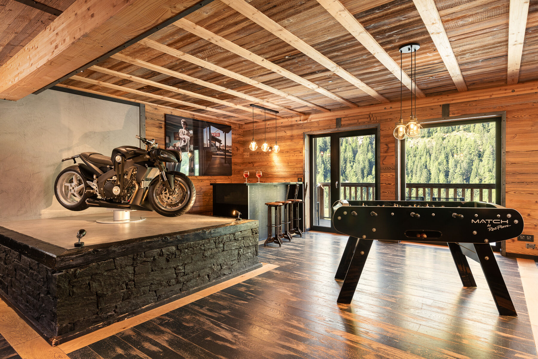 Chalet Hearth's games room in Tignes, with a motorcycle on display beside the foosball table