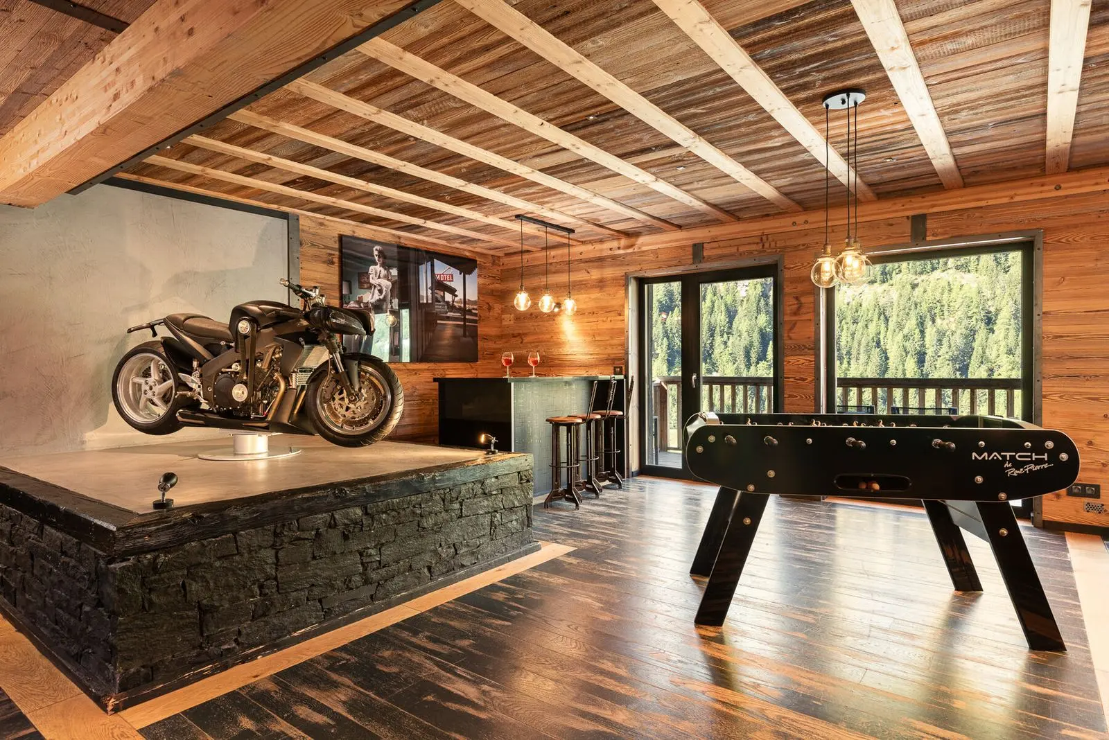 Chalet Hearth's games room in Tignes, with a motorcycle on display beside the foosball table
