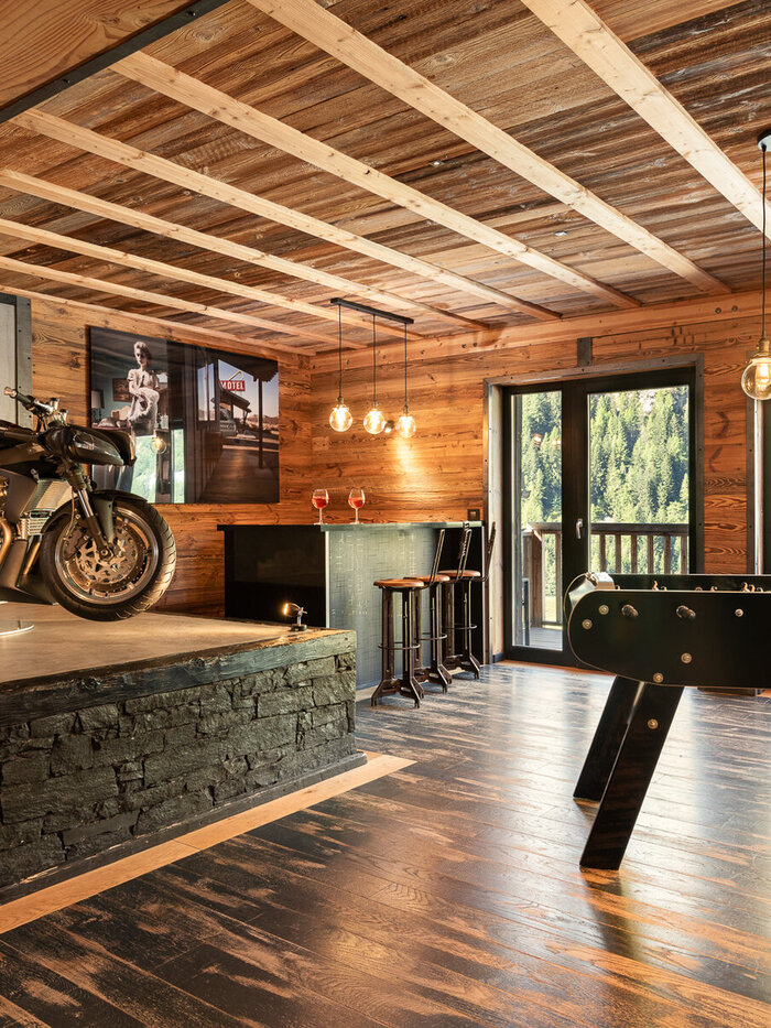 Chalet Hearth's games room in Tignes, with a motorcycle on display beside the foosball table