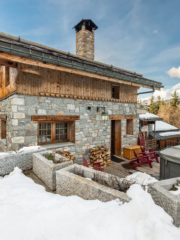 Chalet Ivory's stone-and-timber exterior in Courchevel, framed by snow-covered peaks