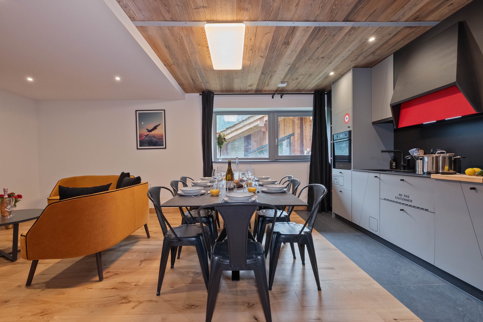 Séjour et salle à manger ouverts de Zephyr dans l'OFF-PISTE Collection à Tignes, canapés en velours moutarde et décor à thème aviation
