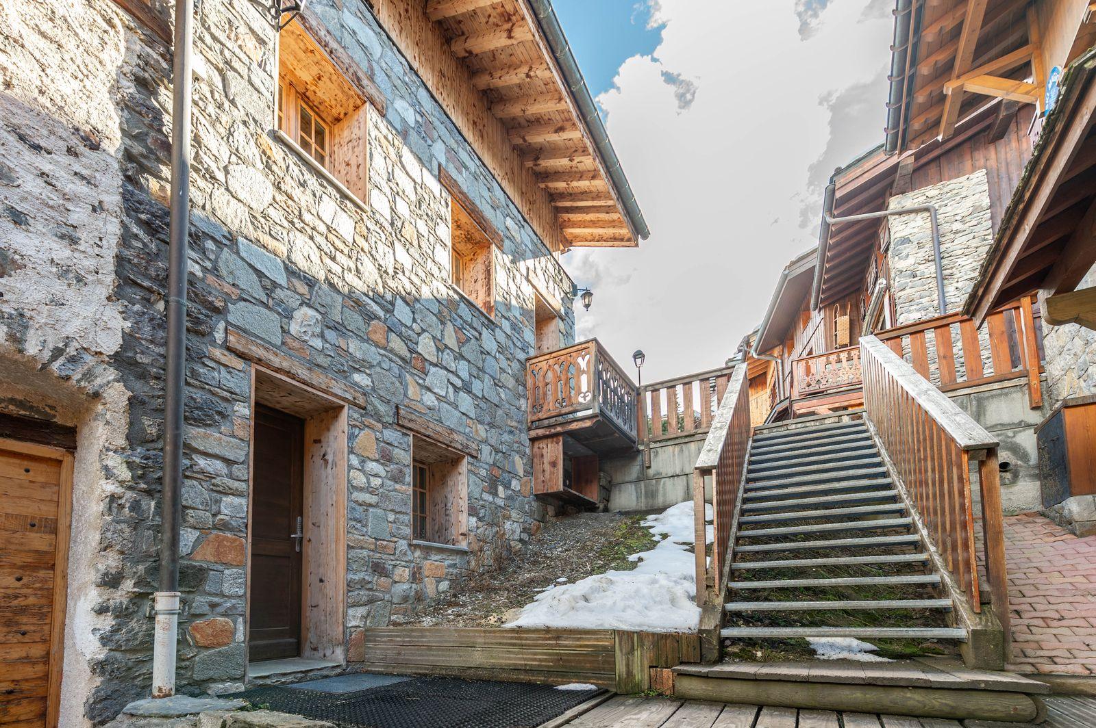 A snowy stone-and-wood village lane in the French Alps